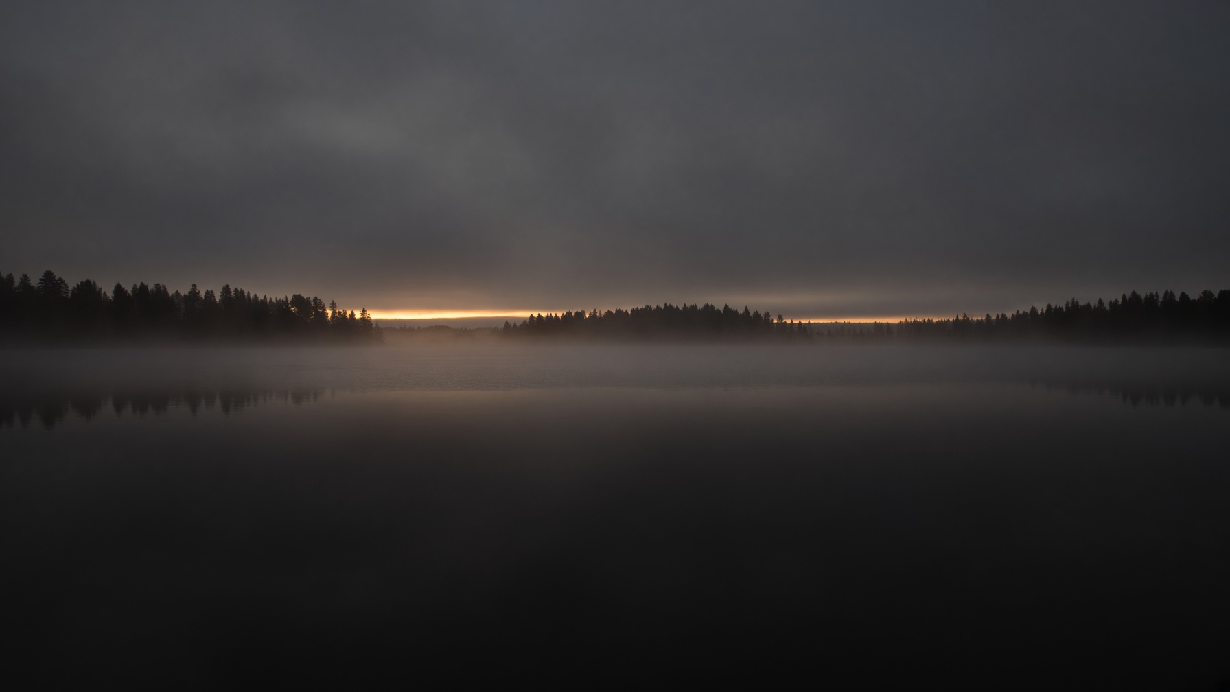 Placeholder photograph [IMAGE]: a still lake at dusk under low fog